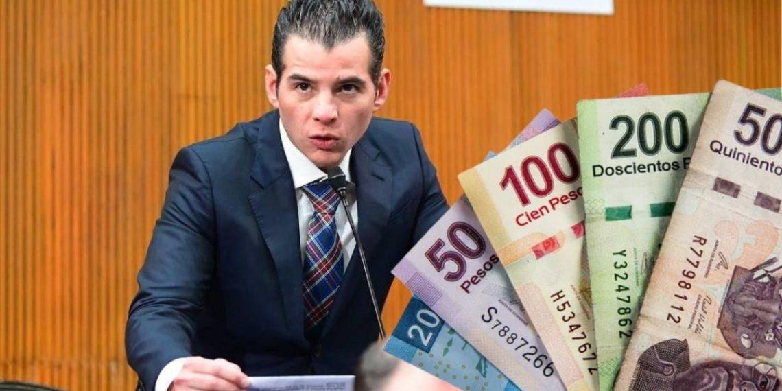 Man in a Suit Speaks into a Microphone at a Podium, with Colorful Banknotes Fanned to the Right, Suggesting Money or Bribery. - Tu Colonia Regia
